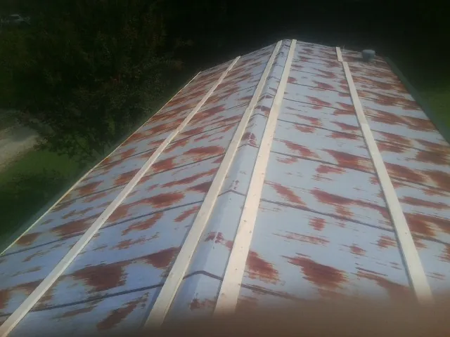 Rusted metal roof panels with new wood purlins before replacement — Storm Damage Roof Repair in Croswell by Roofing Brothers