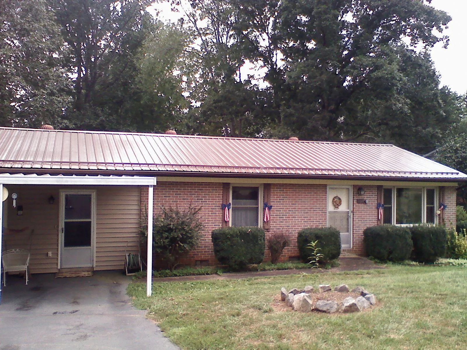 Bronze metal roof and carport on a brick ranch home — Roof Repair work by our crew in Croswell